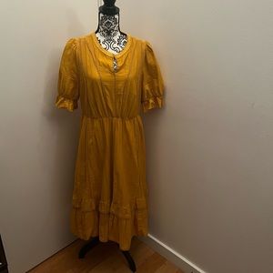 Eshatki goldenrod dress with ruffled bottom and ruffle sleeves.